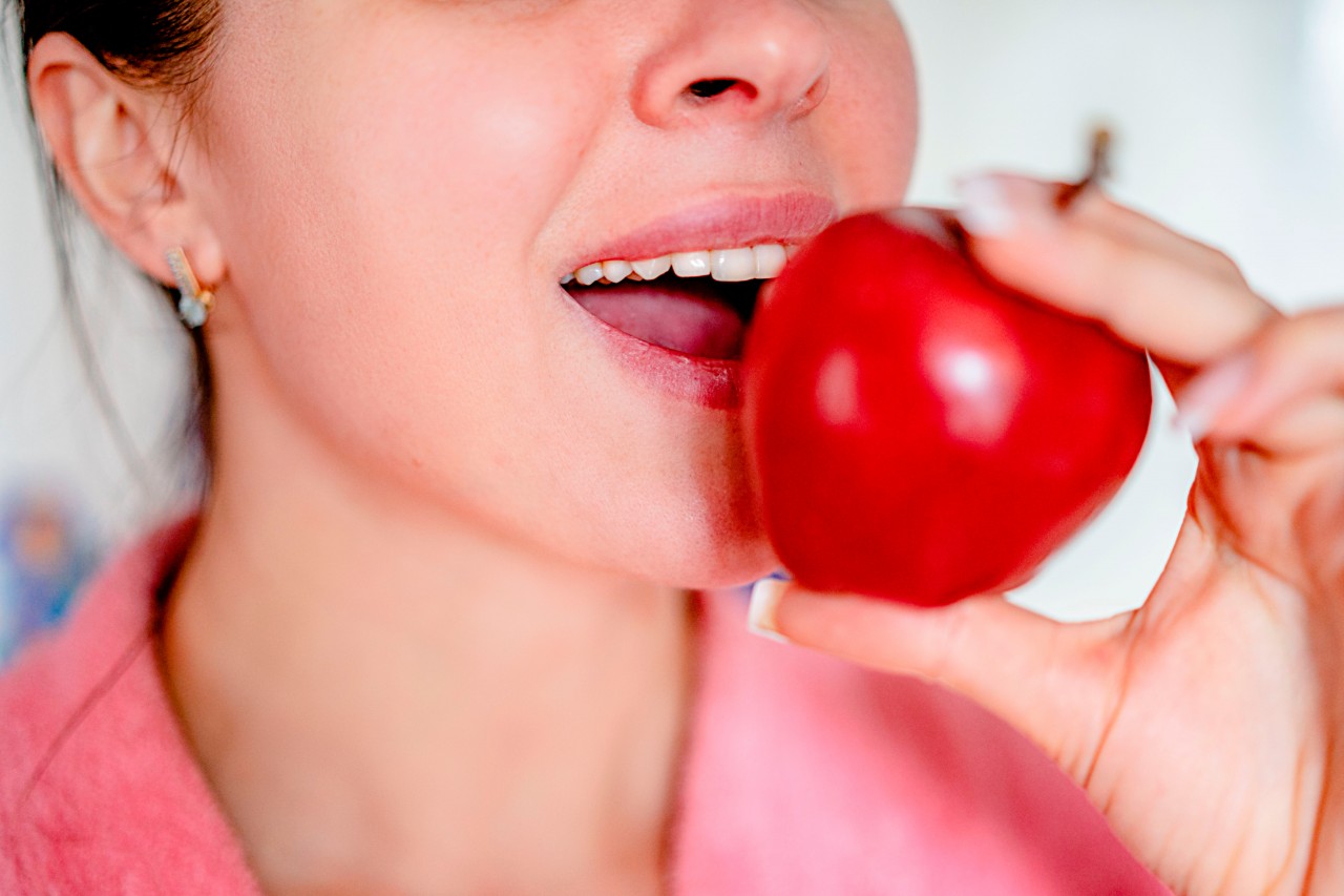 Cropped view of woman eating apple