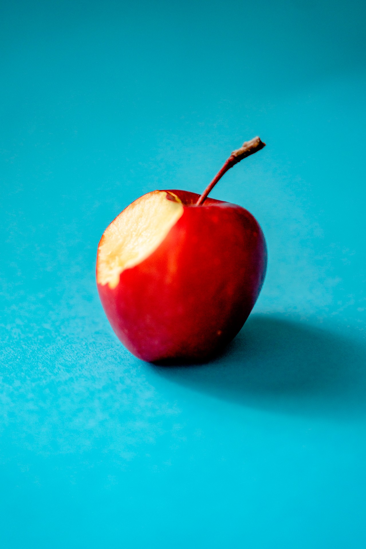 Bitten red apple on the blue background
