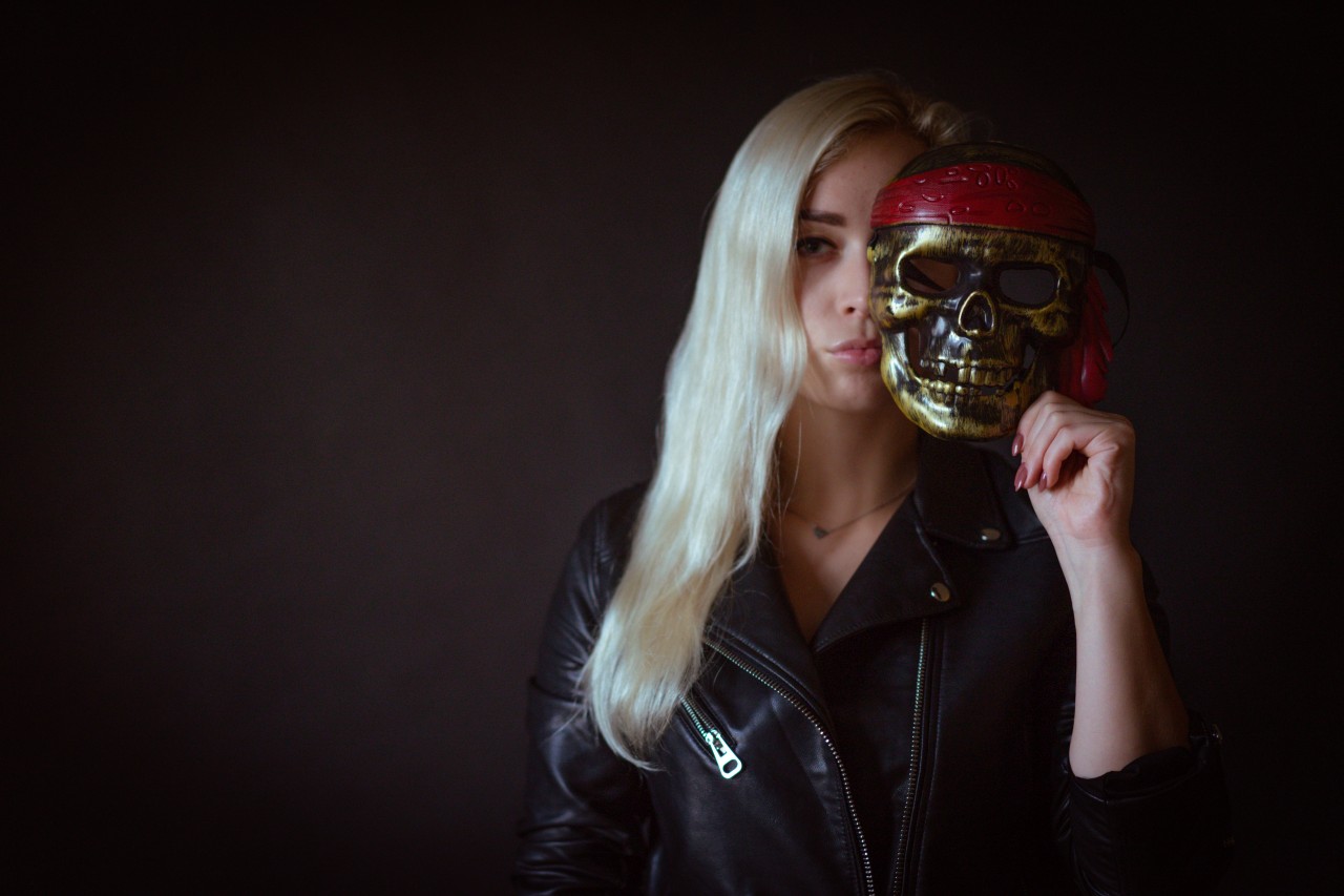 Stylish blonde woman with Halloween skull mask
