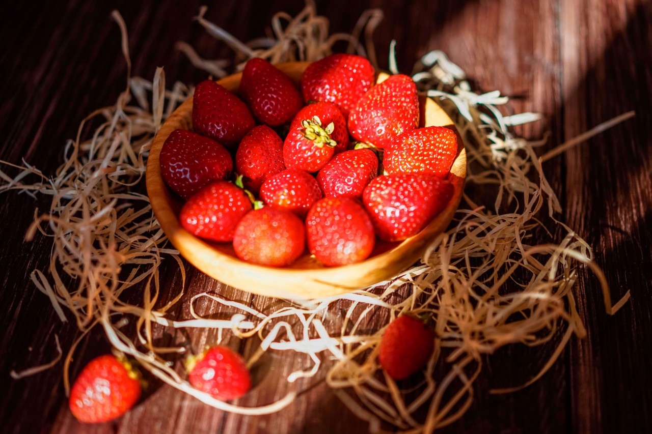 Strawberry in a Wooden Plate on a Straw