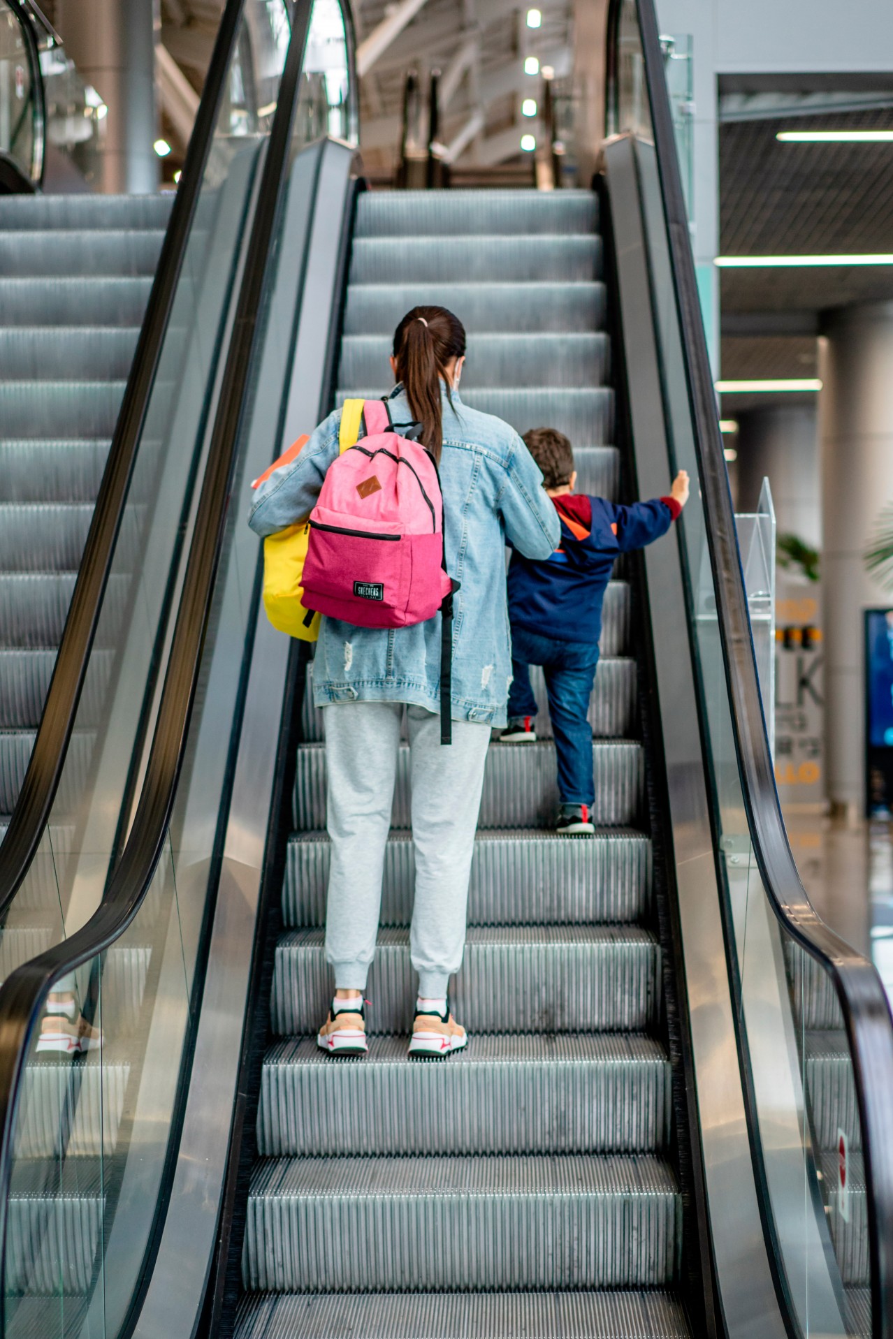 Woman and kid on the airport escalator