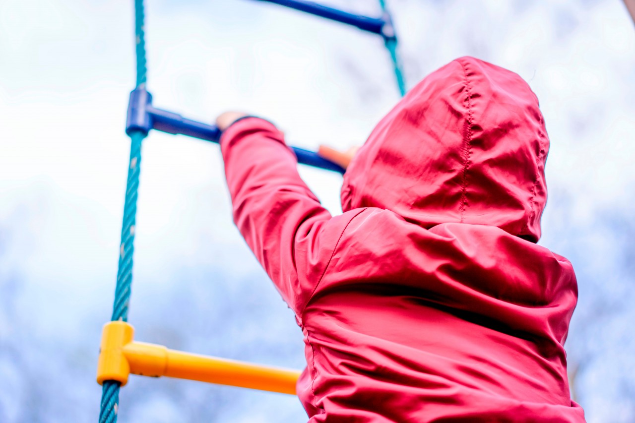 Kid in a red jacket at the playground