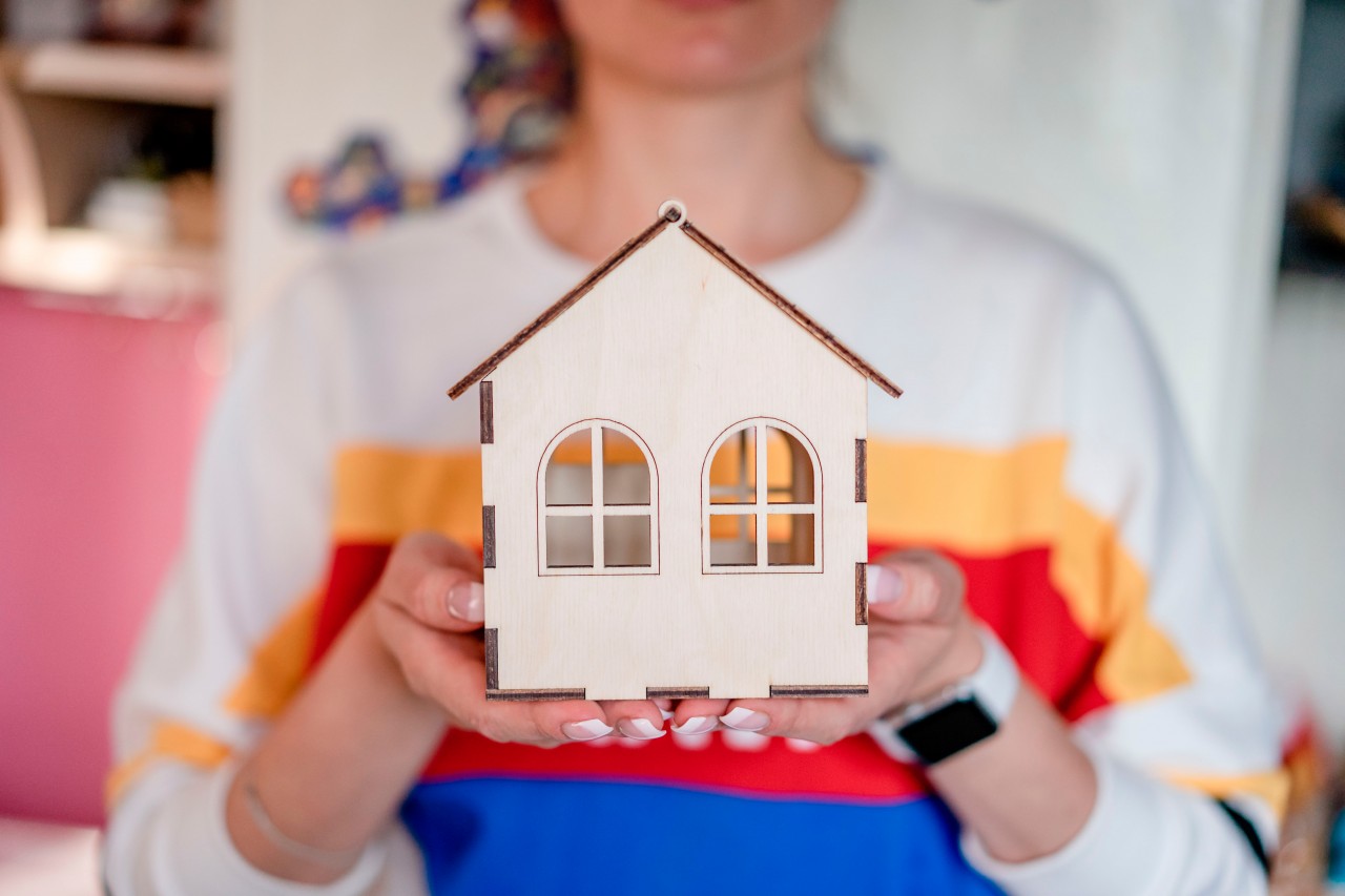 Realtor woman holding toy wooden house