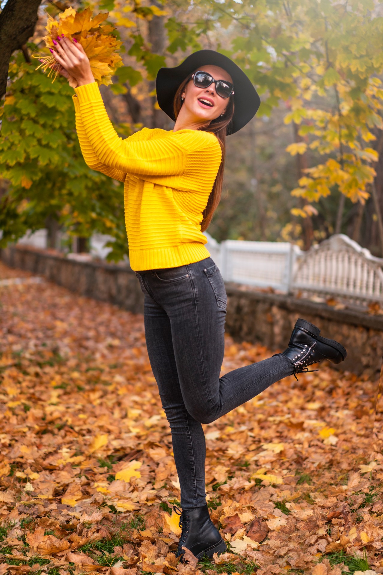Stylish young woman in hat enjoying autumn day