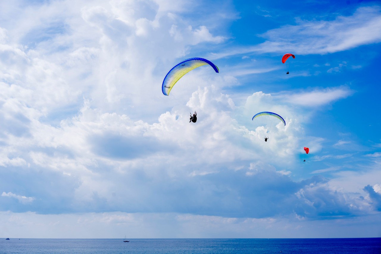 Paragliders in the blue sky above the sea