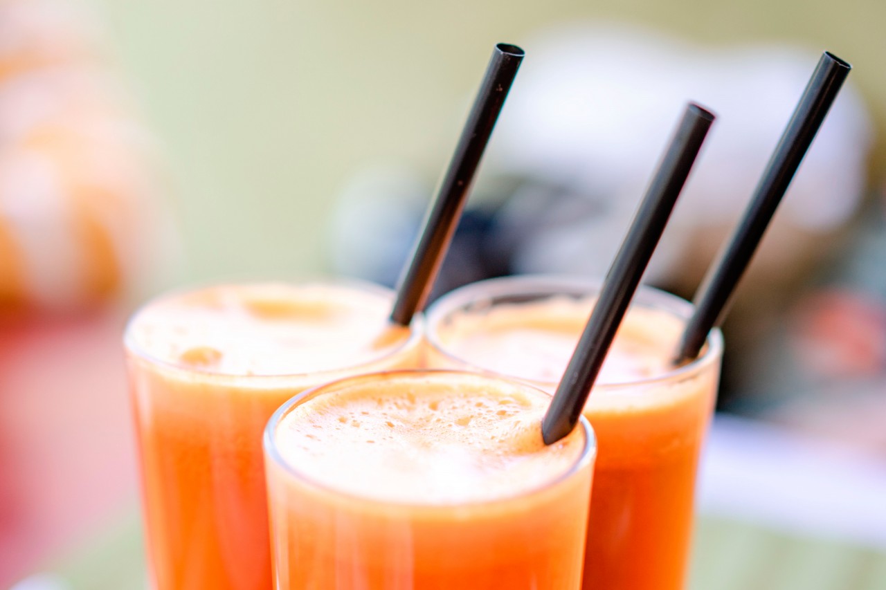 Three juice glasses with straws