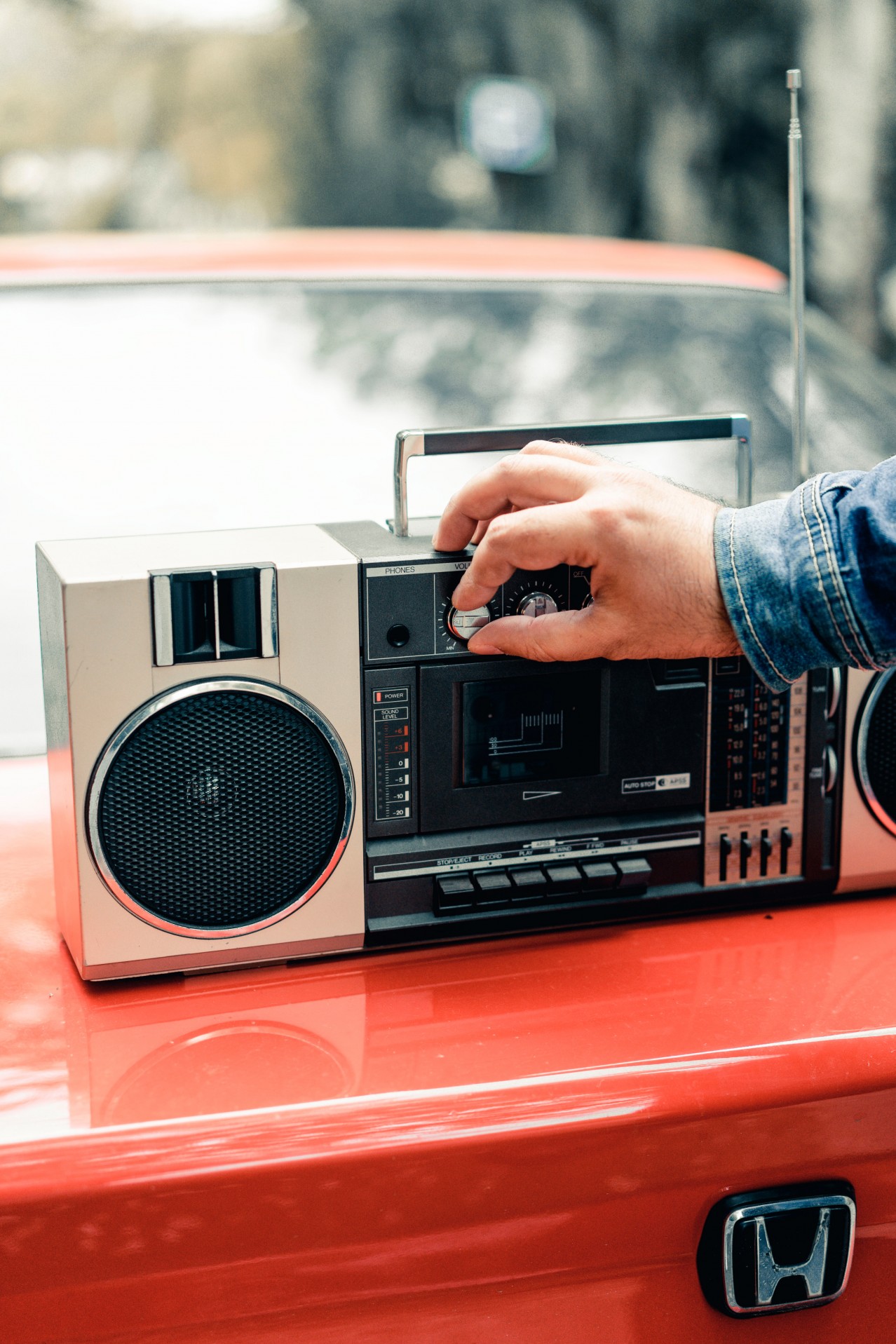 Man with retro boombox and red vehicle