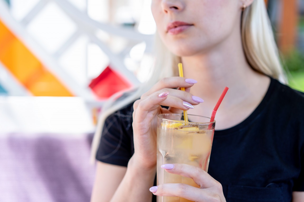 Blonde woman drinks cocktail