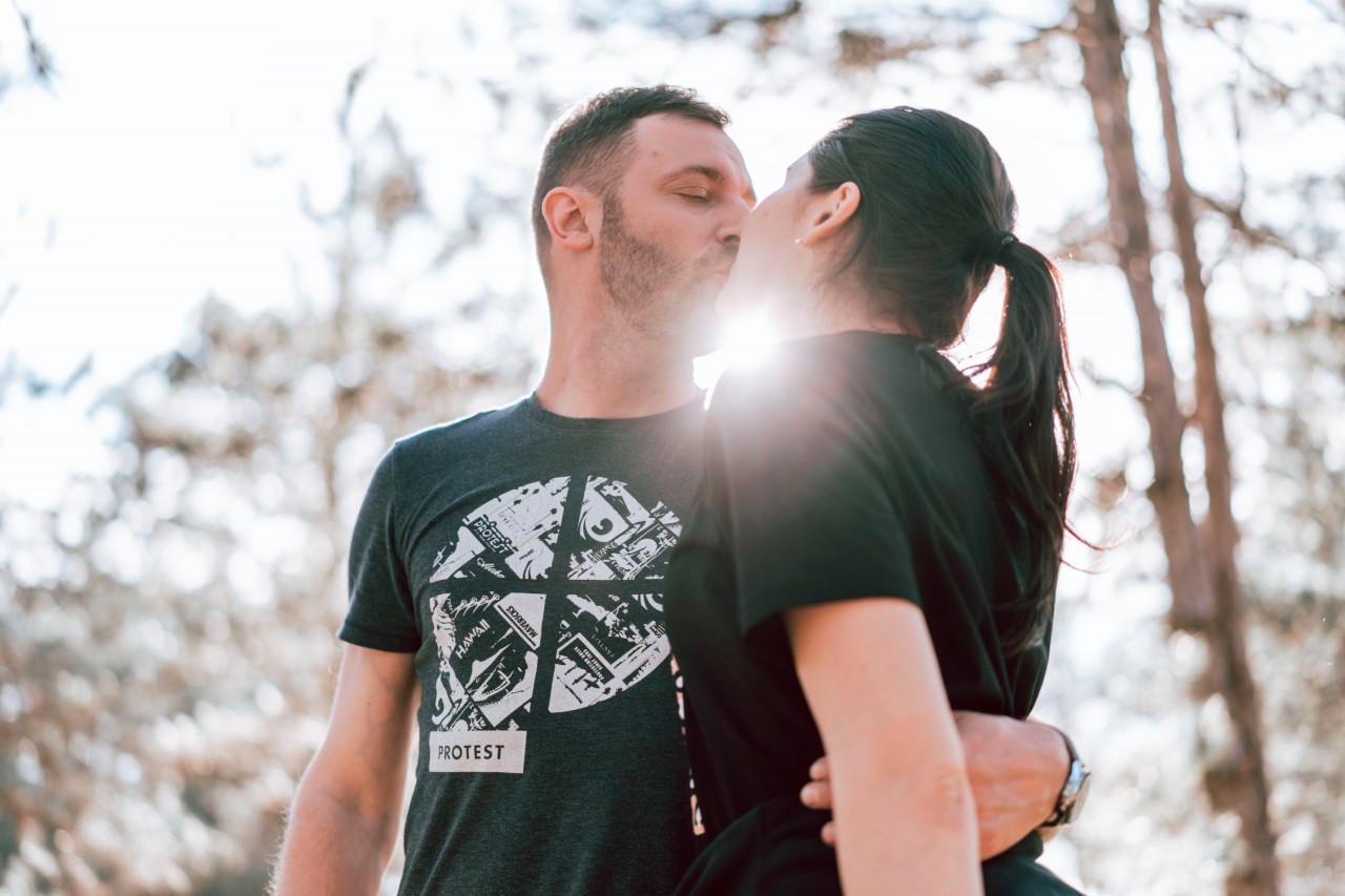 Kissing couple on the blurred nature background