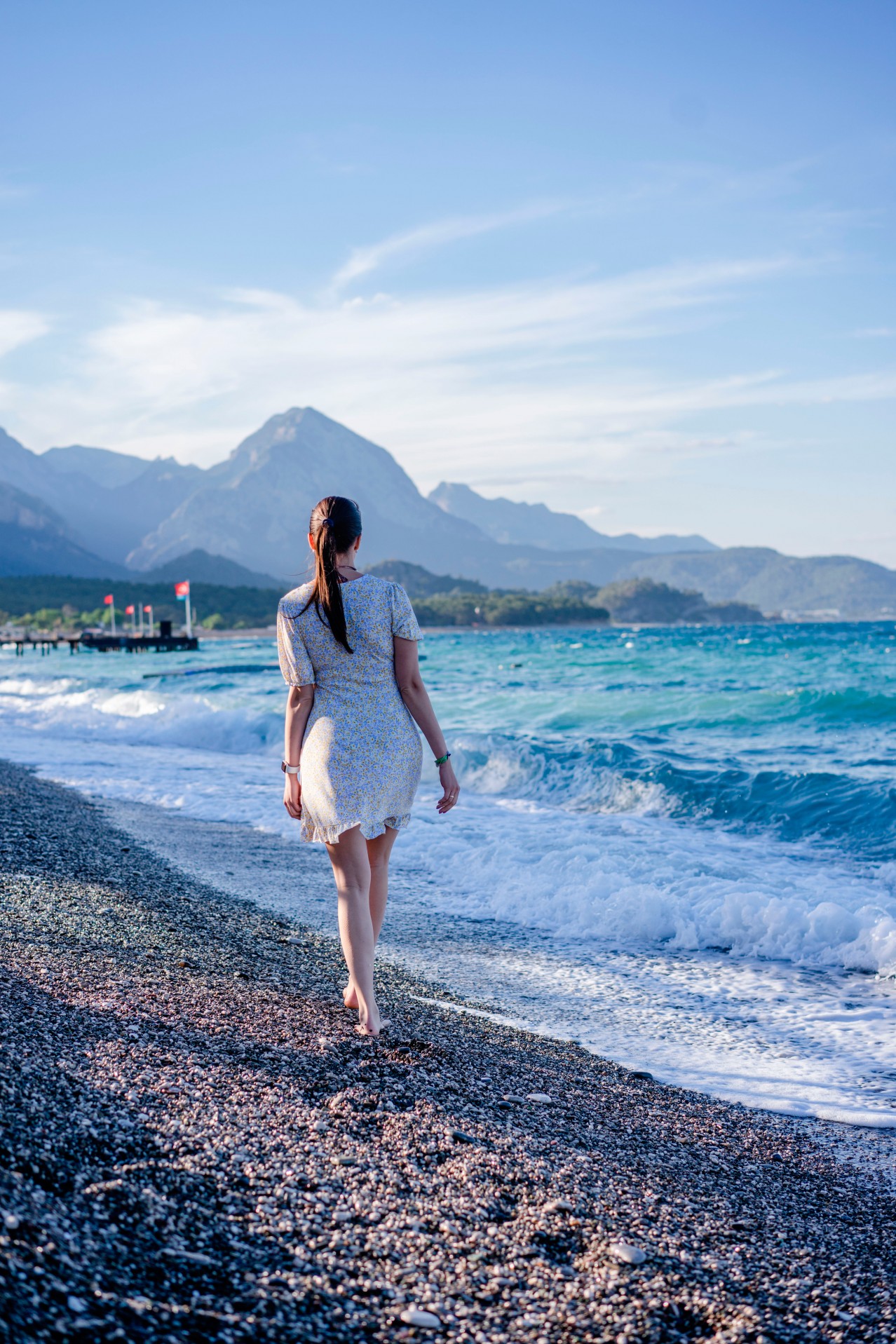 Woman in dress walking down the sea shore in Turkey