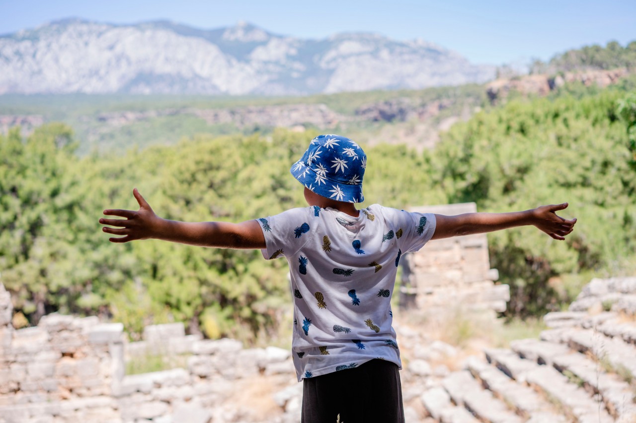 Boy in summer hat enjoys view of the antique amphitheater