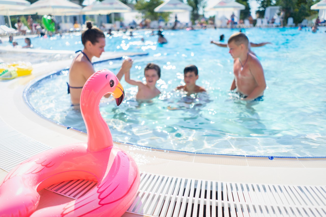 Family having fun in the pool at summer resort
