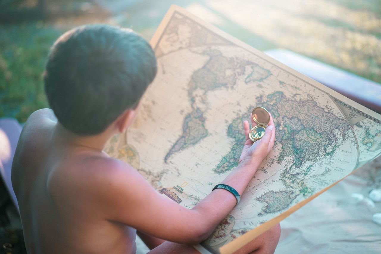 Young Guy Looks at a Geographical Map