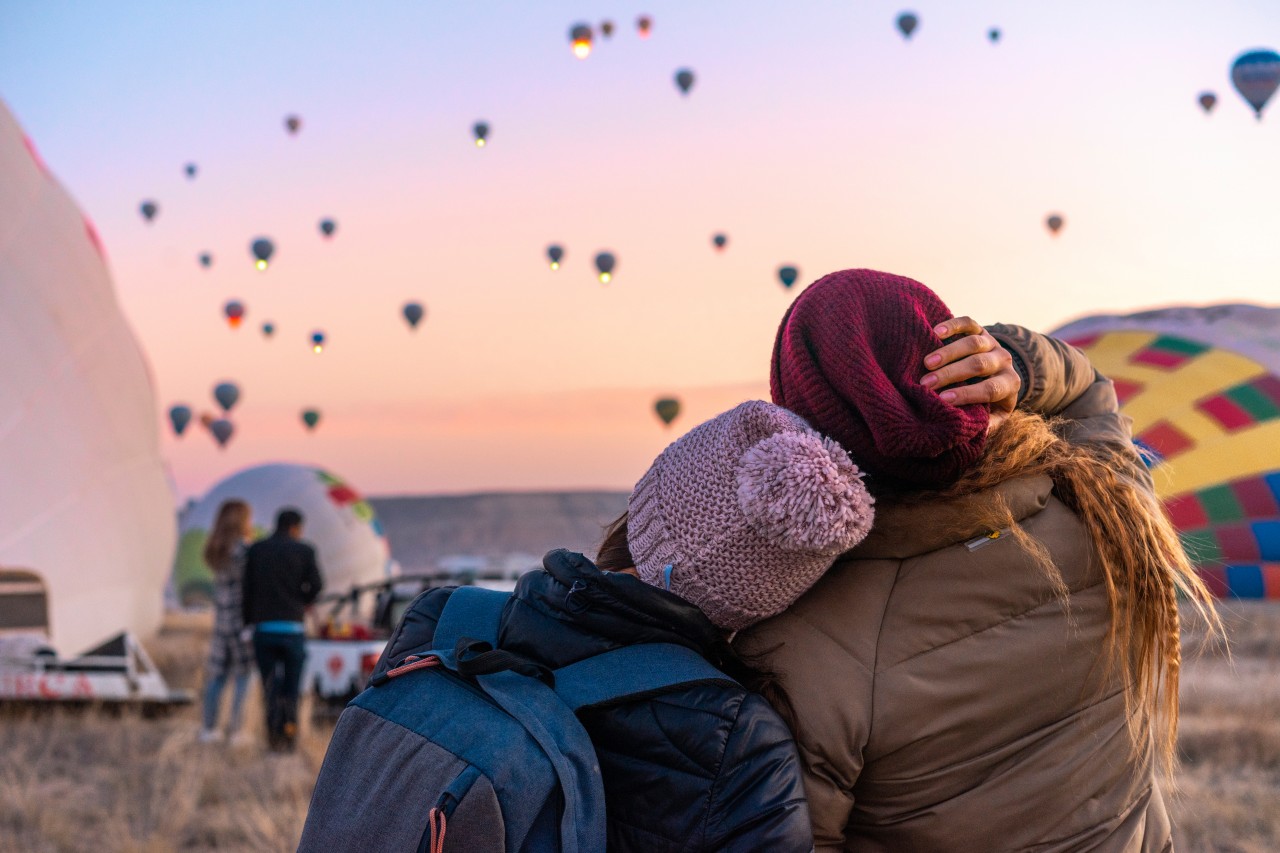 Friends looking at flying balloons in Cappadocia
