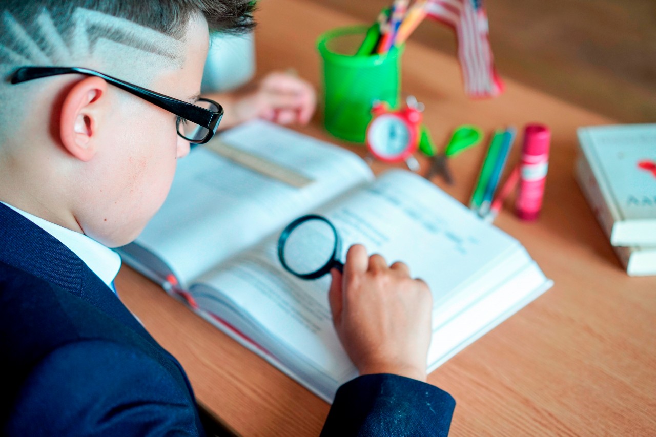 A Clever Schoolboy with a Magnifying Glass in his Hand