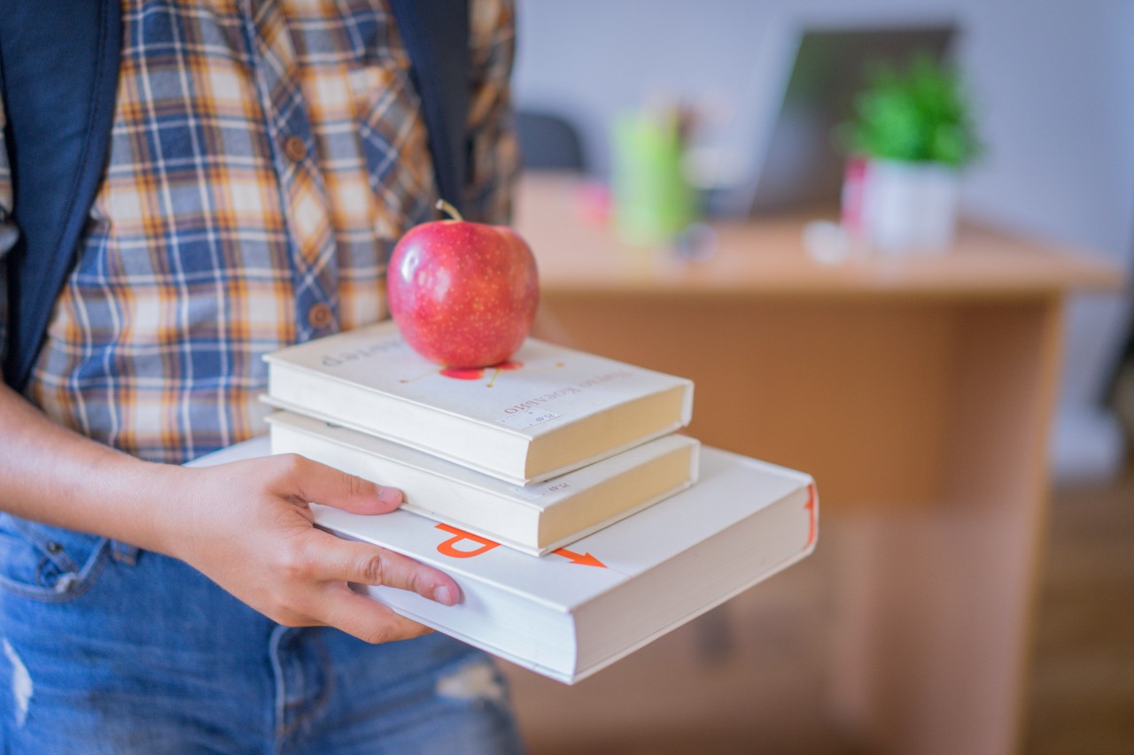 A Schoolboy with Books and an Apple in His Hands