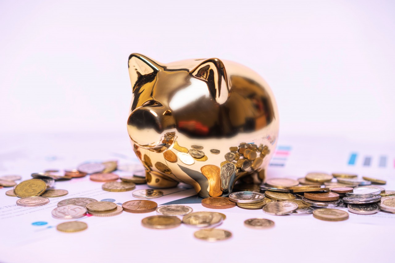 Piggy Bank and Coins on a Light Background