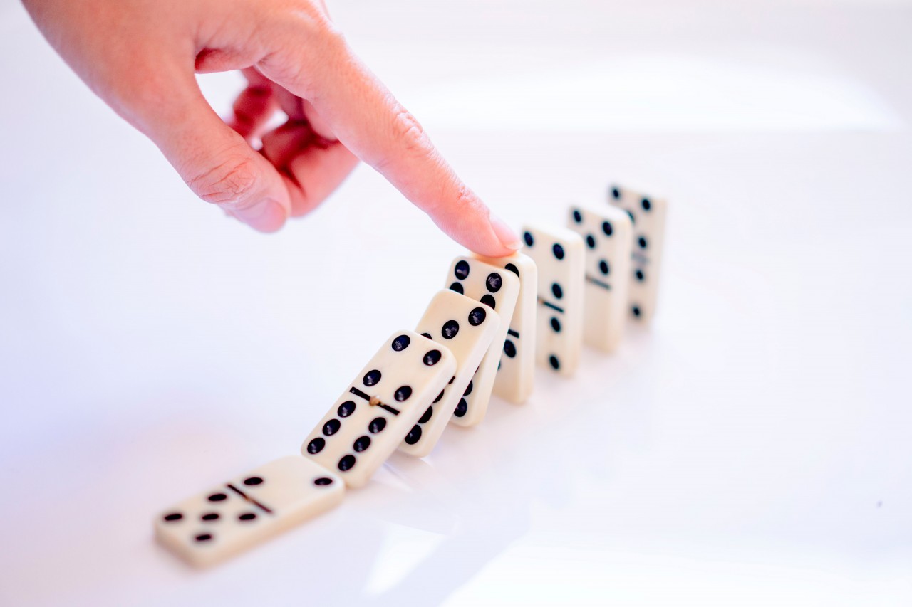 Hand touches dominoes dices
