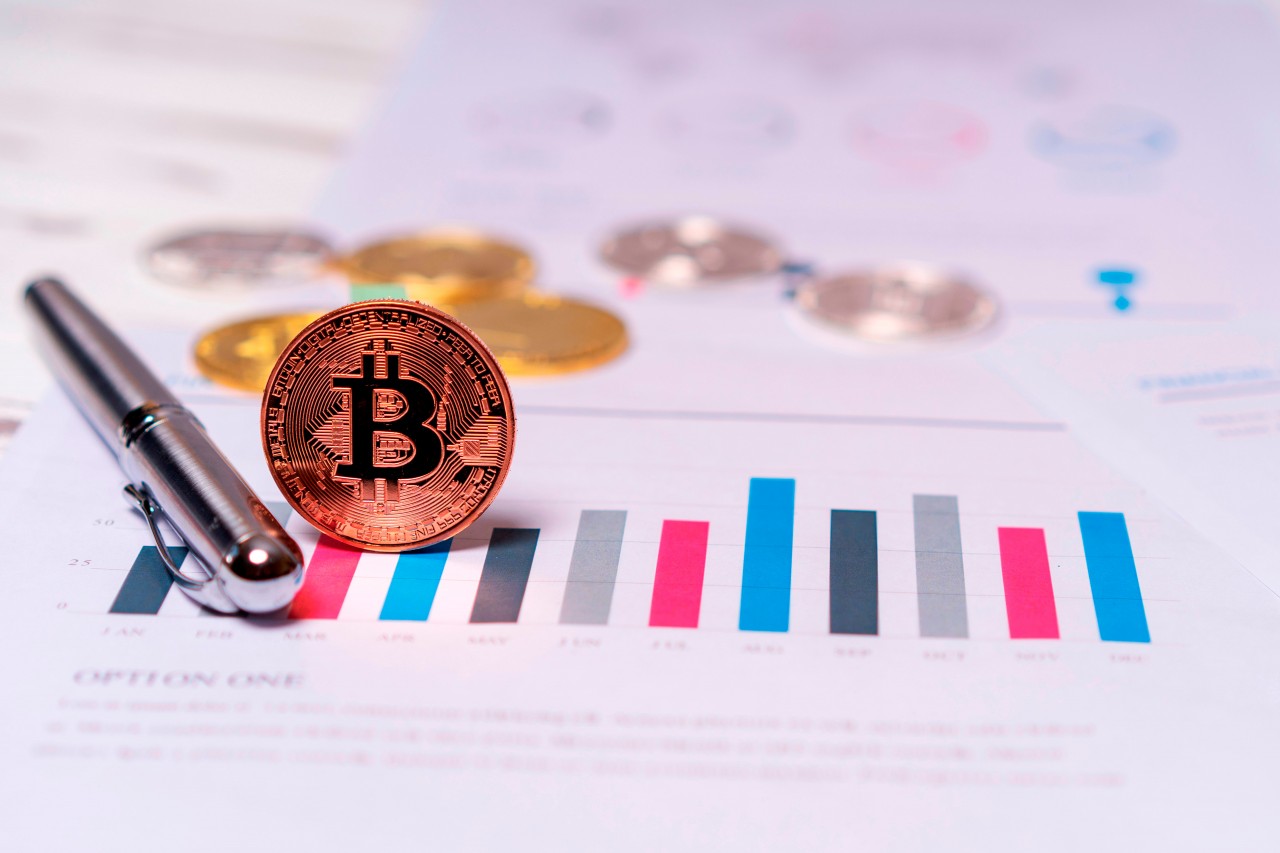 Bitcoin with Financial Documents on the Table