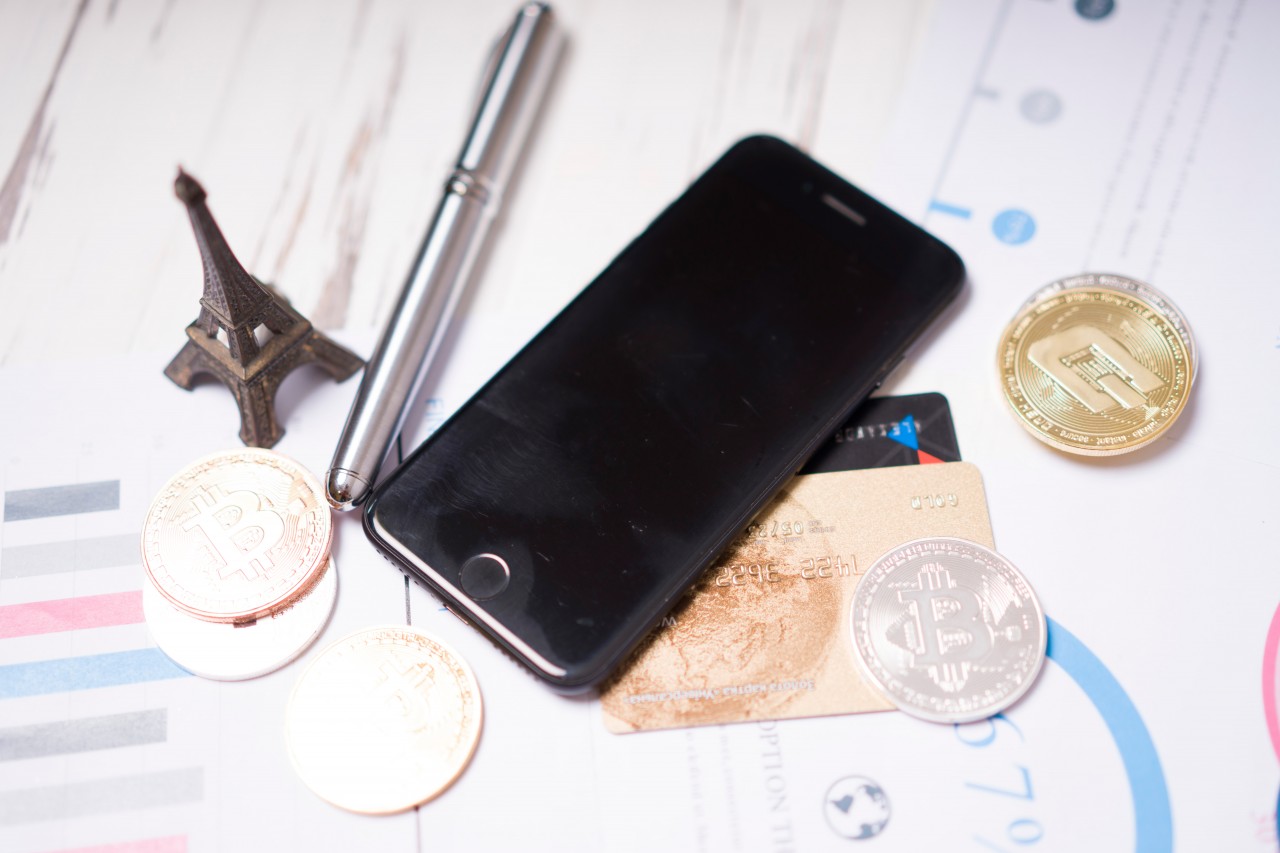 Smartphone, bitcoins and Eiffel Tower on the documents