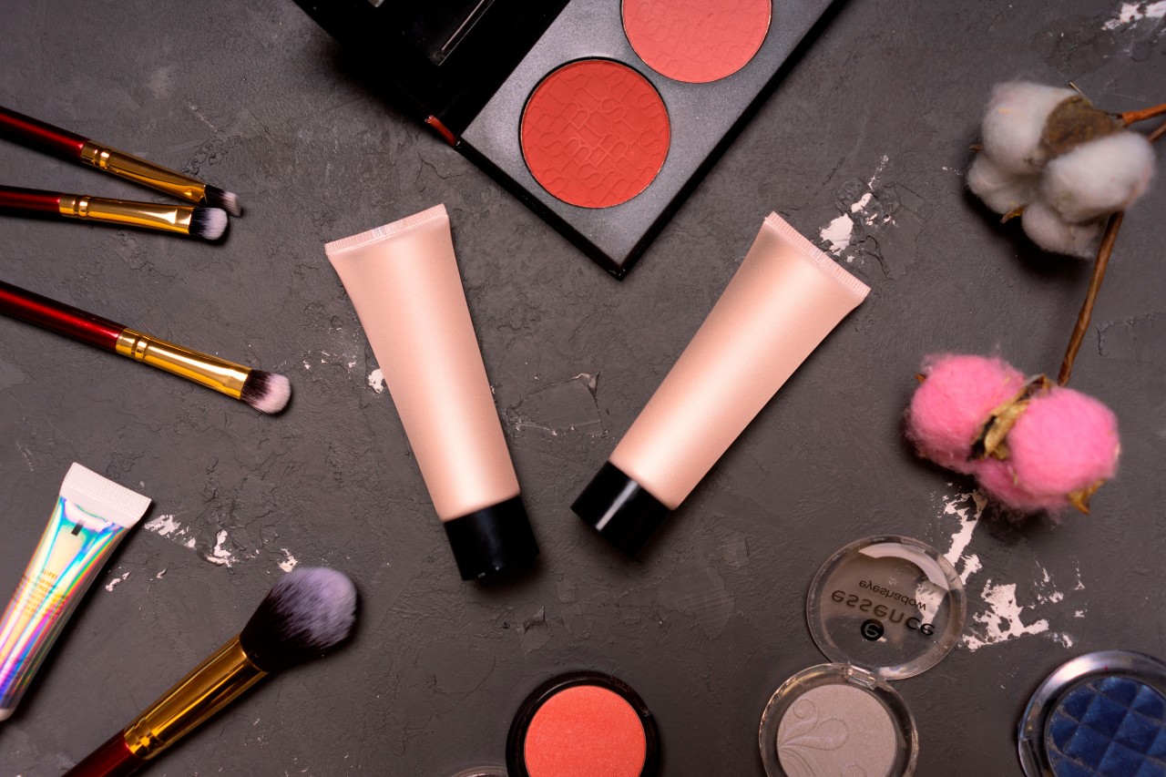 Decorative Cosmetics with Makeup Brushes on a Gray Background