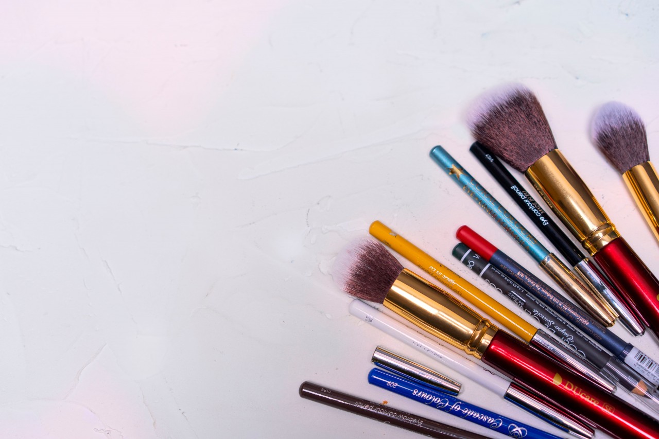 Makeup Brushes with Pencils on a White Wooden Background