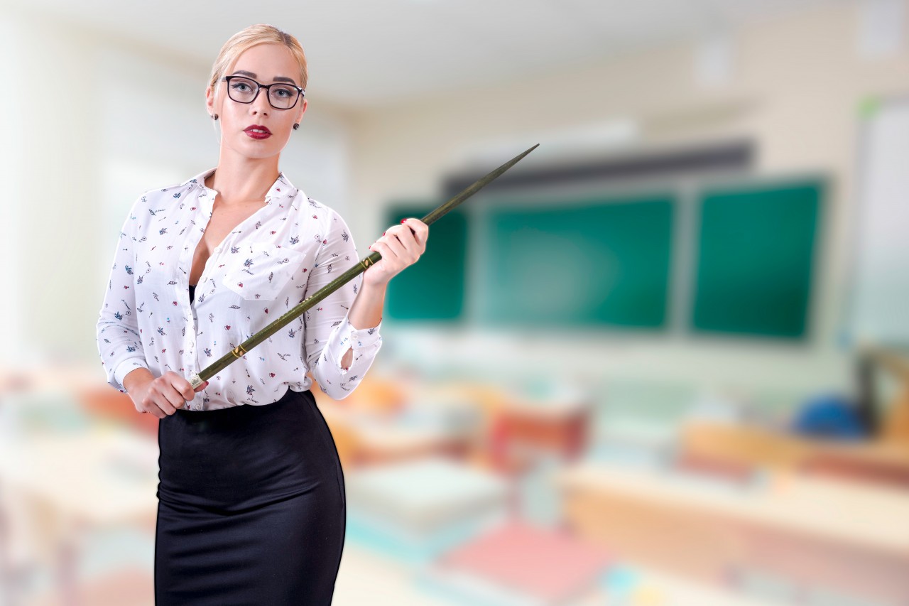 Sexy teacher on a blurred classroom background
