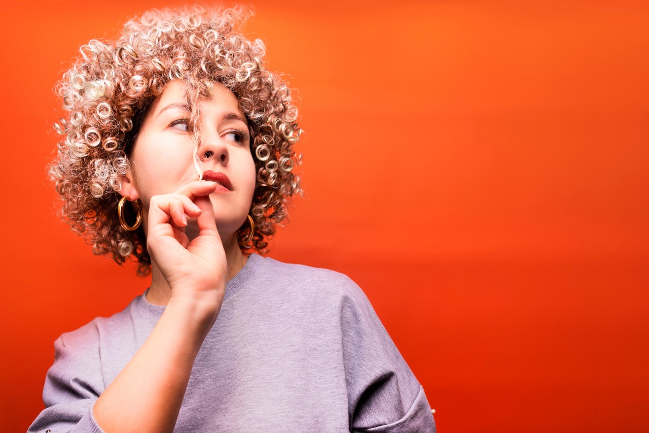 Funny Woman with Curls on an Orange Background