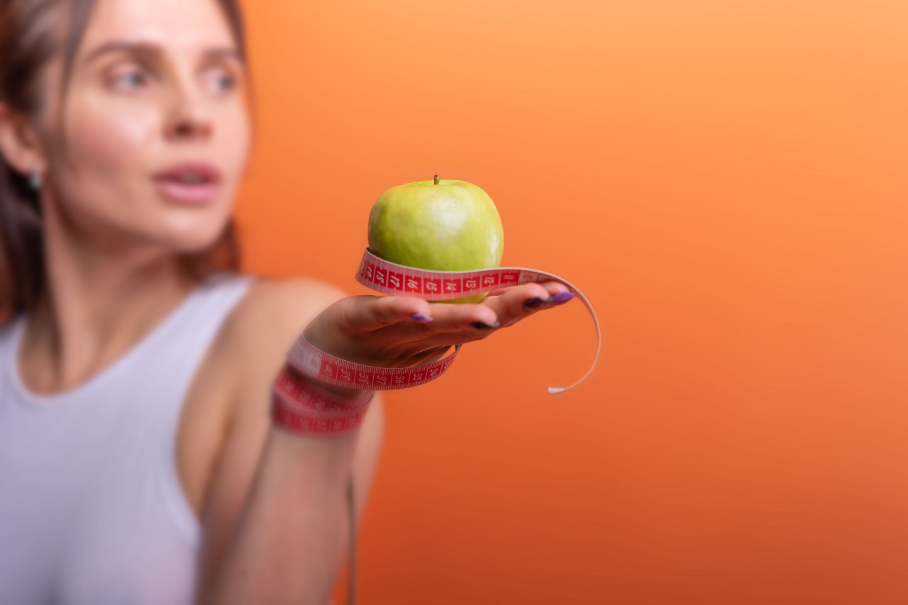 Fitness Girl with a Green Apple in Hand