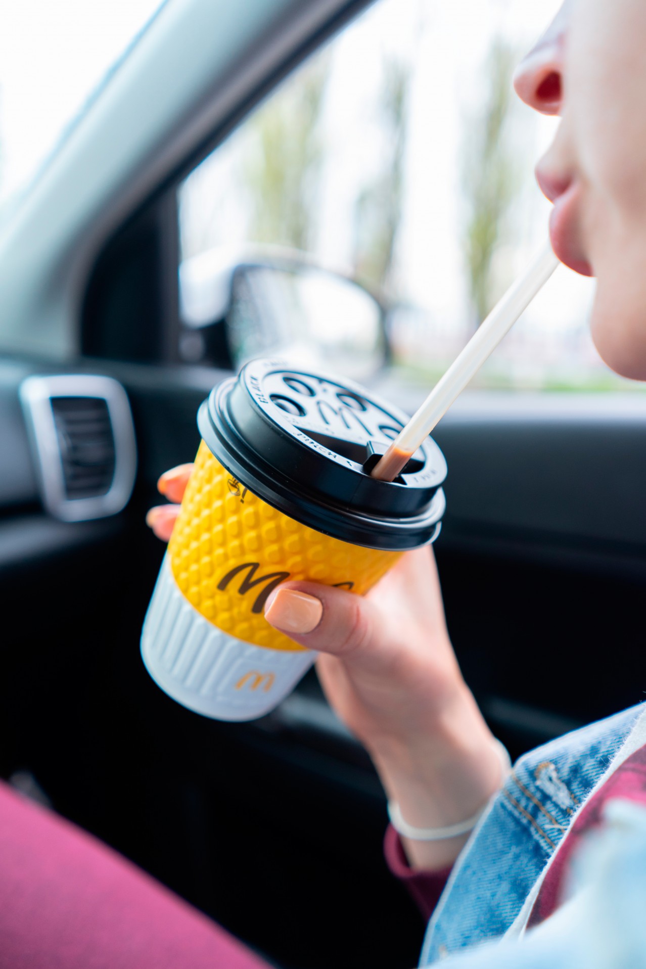 Woman drinks coffee in the car