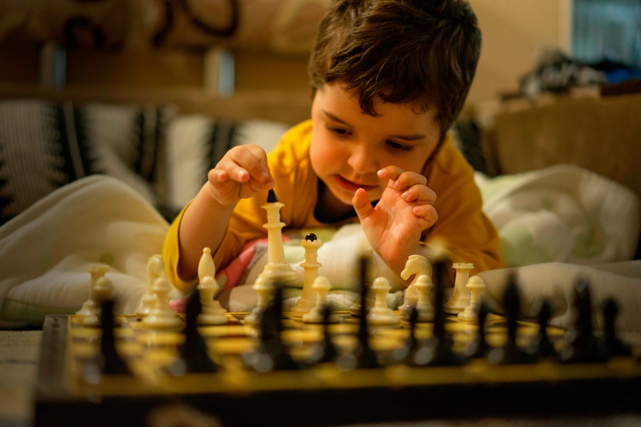 Dark-haired kid plays chess