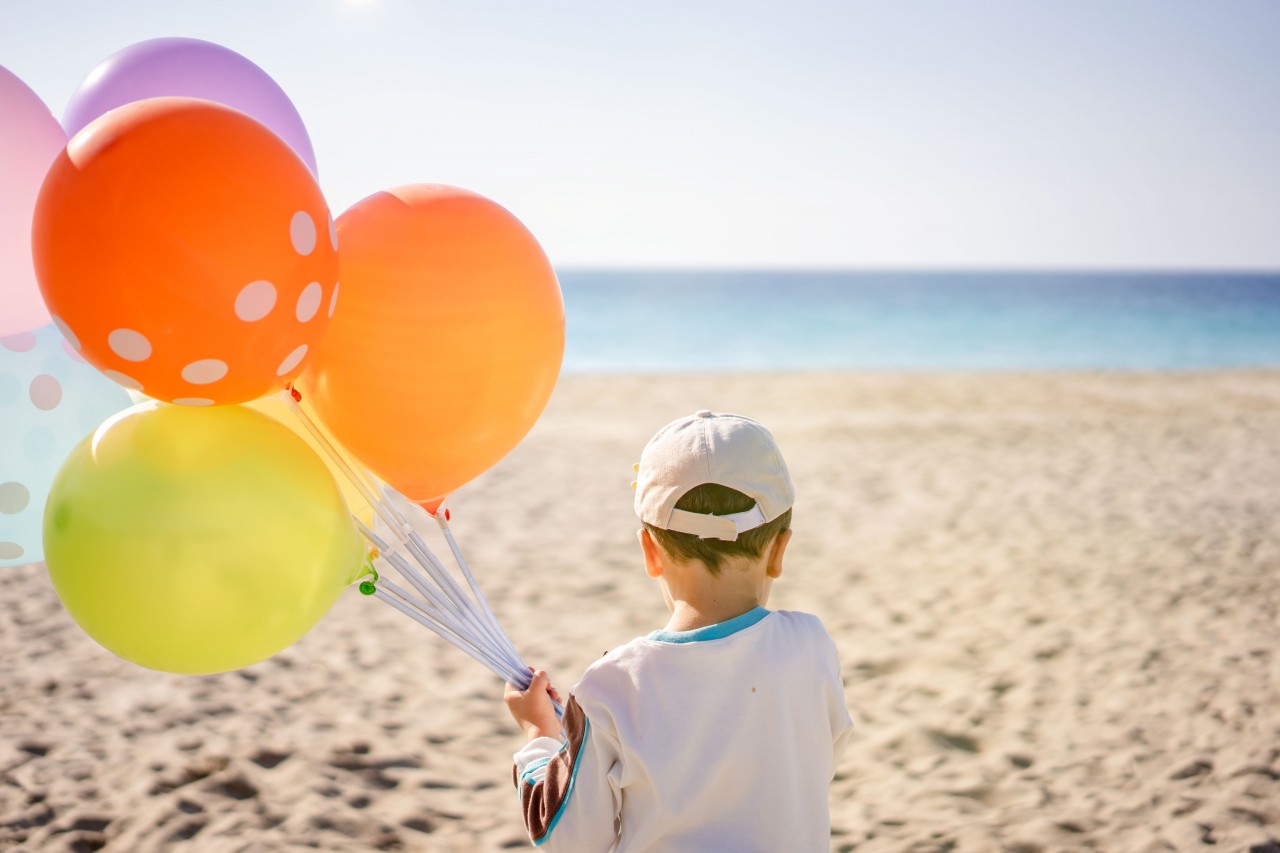 Little Boy with Colorful Balloons in His Hand