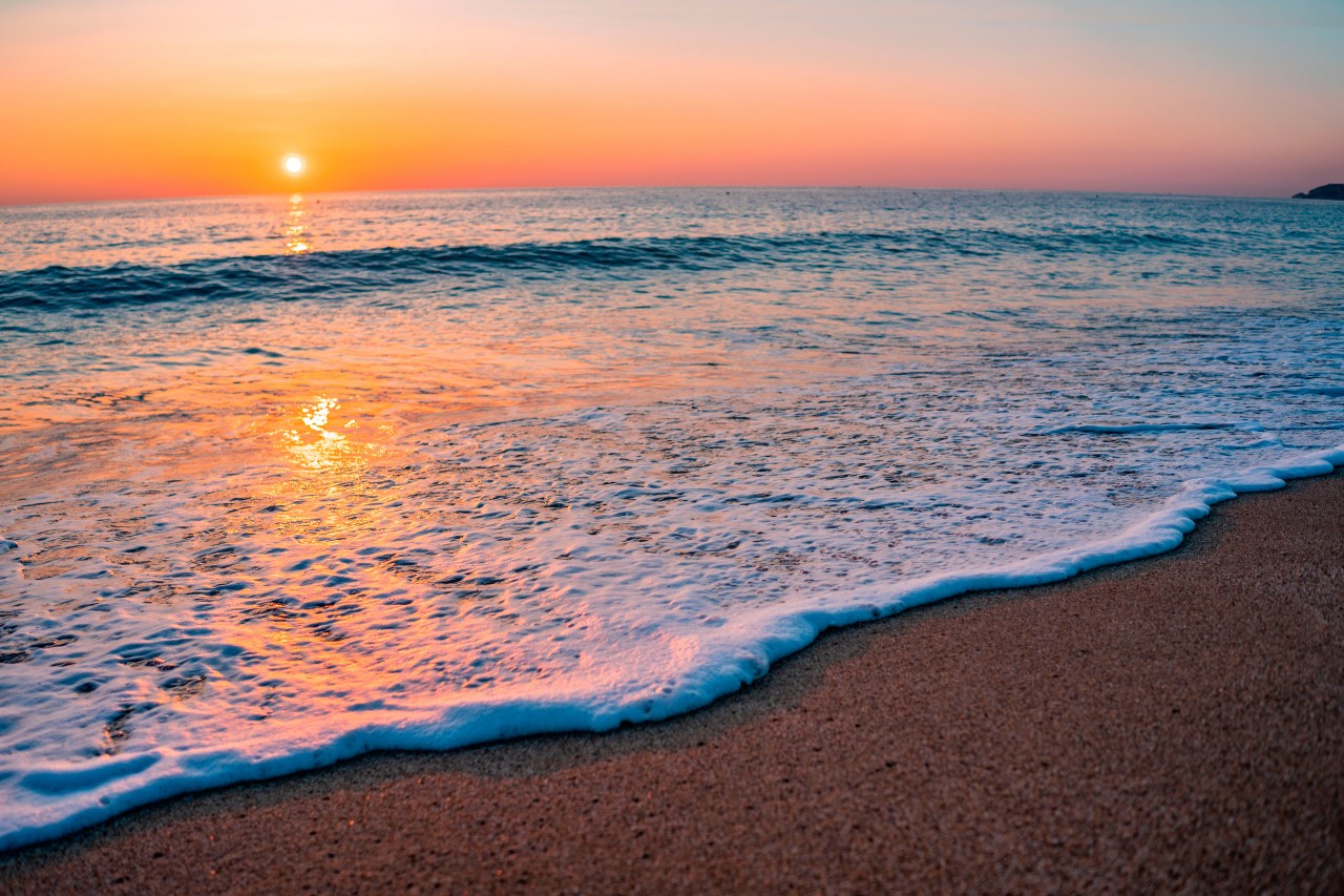 Summer wallpaper with sea waves on the sunset