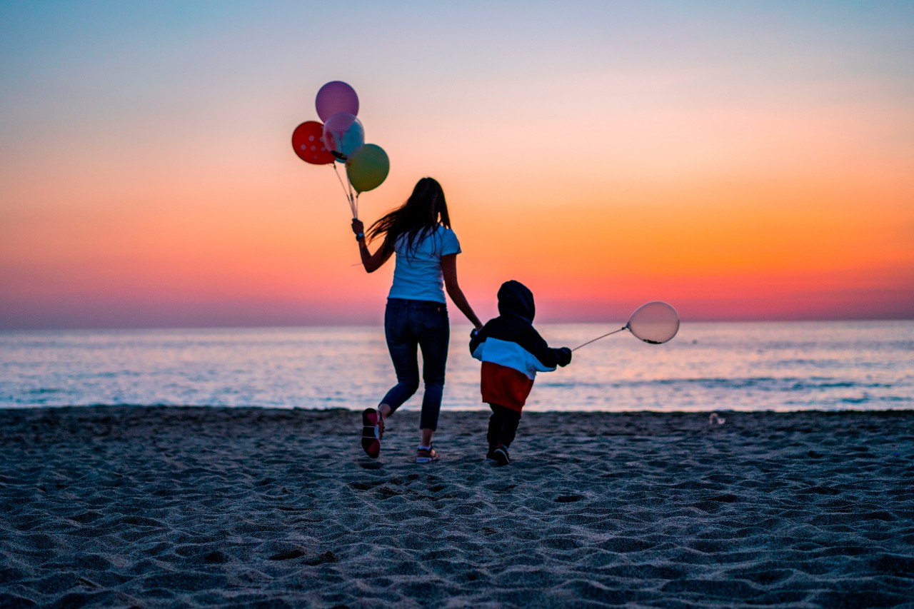 Mother and son with balloons at the sea