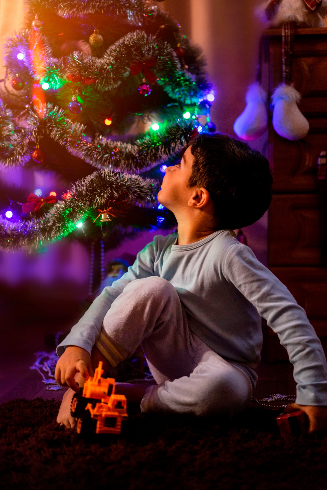 Boy playing near Christmas tree