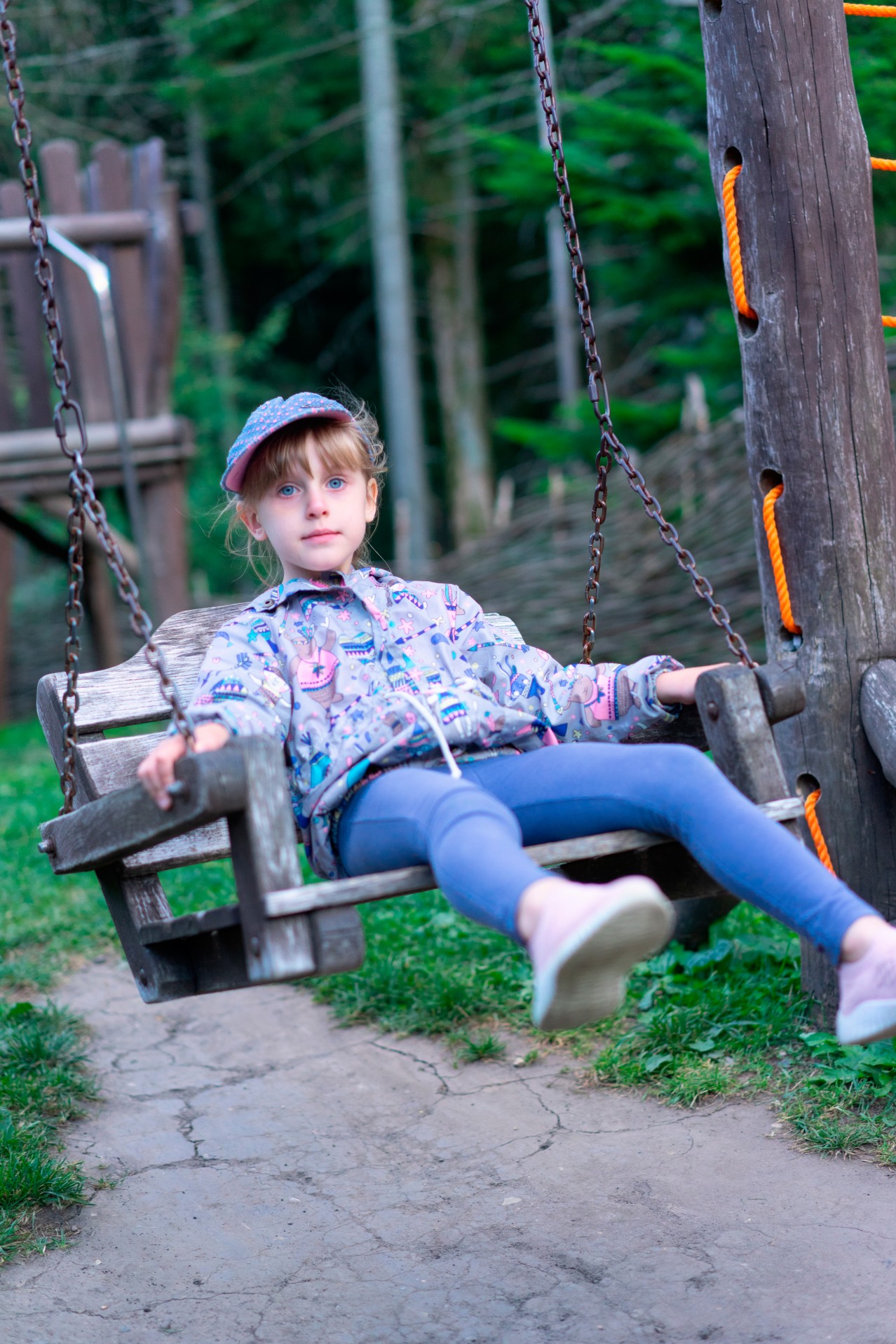 Little girl on the wooden swing