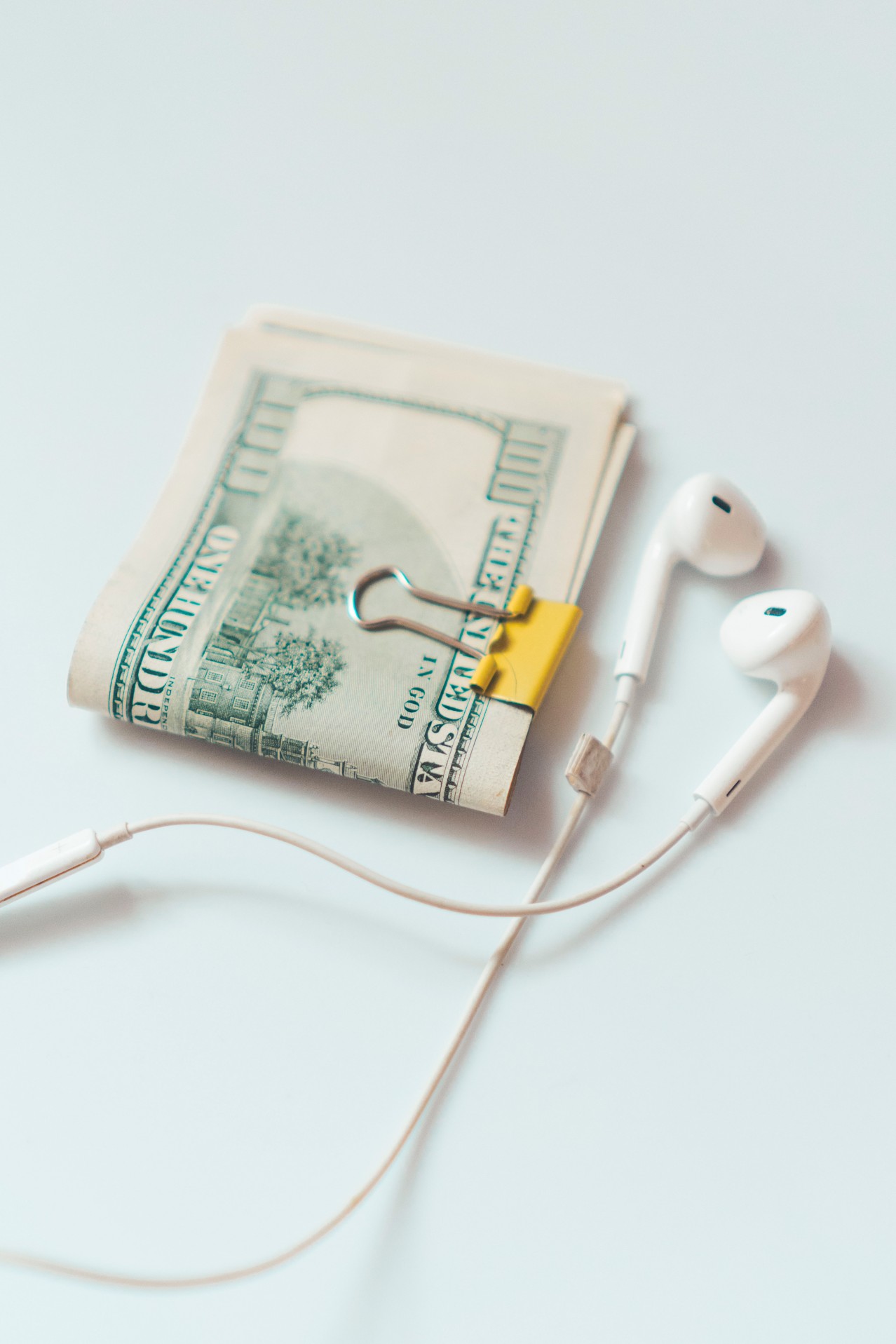 Dollars with Earphones on a White Background