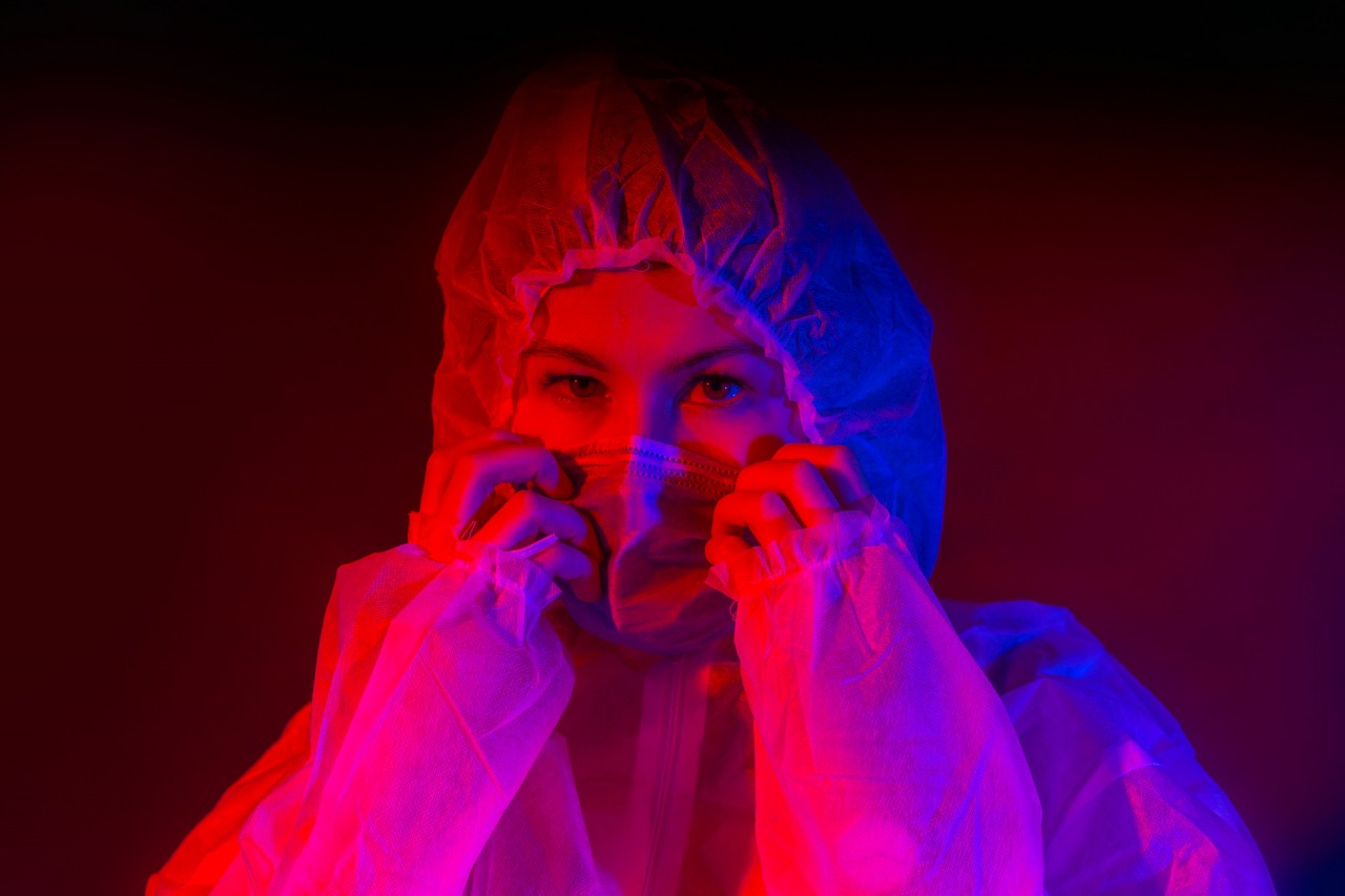 A Woman in a White Protective Suit and Mask