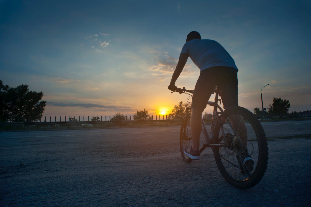 Man riding a bicycle on a sunset